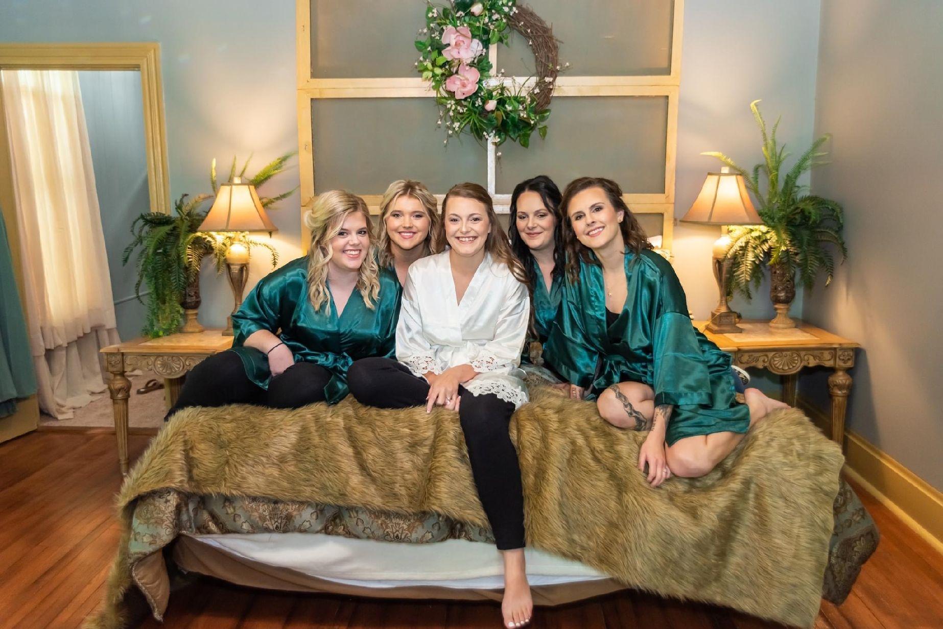 the bride and her bridesmaids in matching green wraps getting dressed in the historic Hayes House