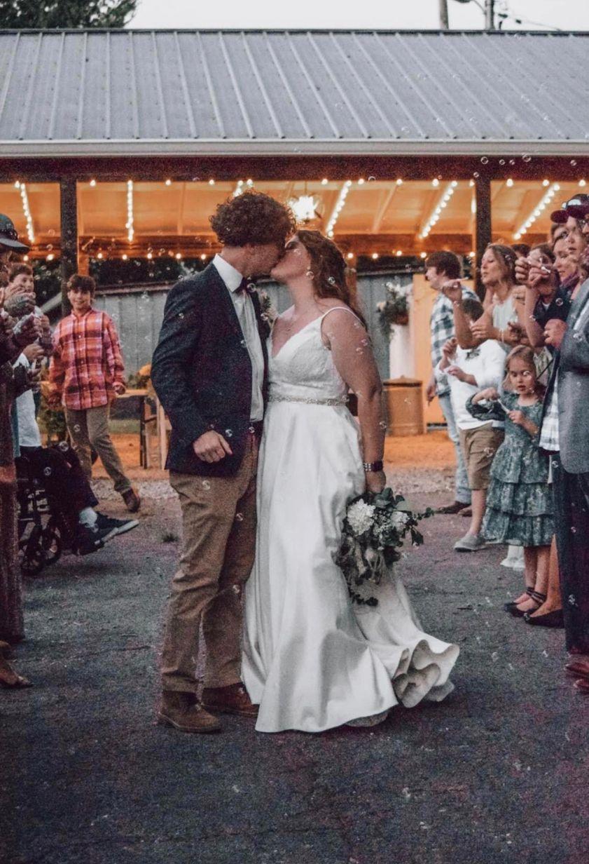 The bride and groom steal a kiss outside the event building