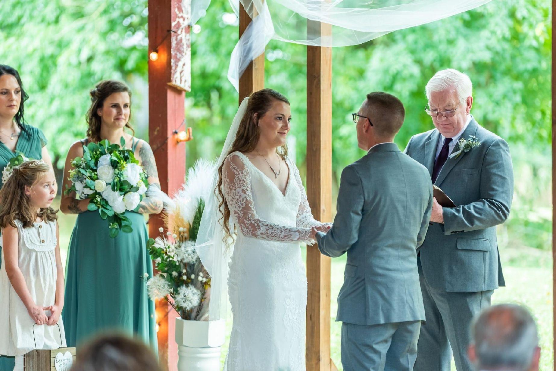 The wedding party look on as the couple exchange vows