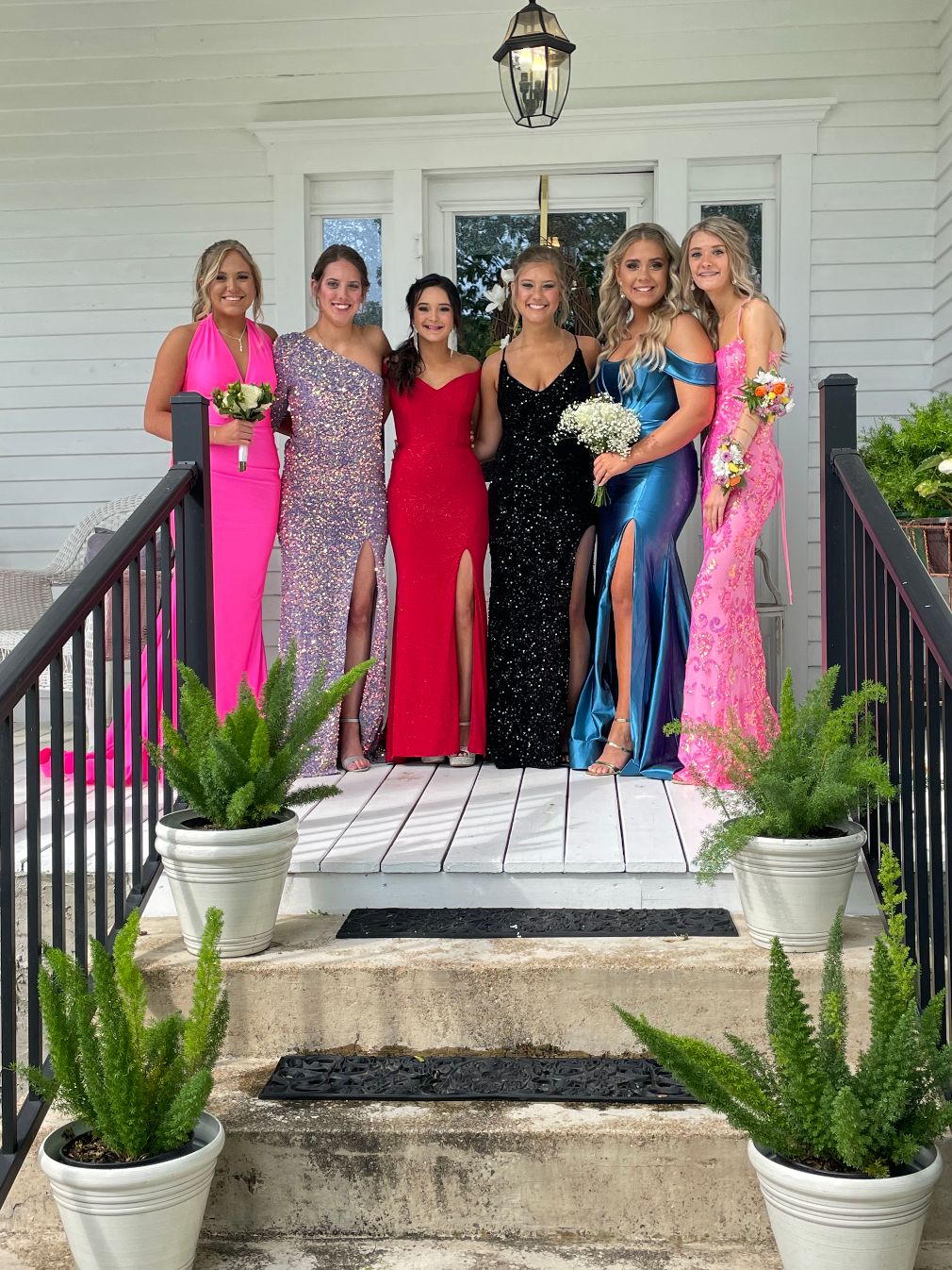 6 women ready for Prom Night standing at the front door on the veranda of Hayes House